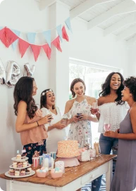 Schwangere Frau und Freundin sprechen stehend bei einer Feier