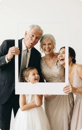 Älteres Paar lächelt verspielt in einem Fotobox-Rahmen