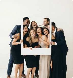 Hochzeitsgäste haben Spaß und posieren mit einem Fotobox-Rahmen